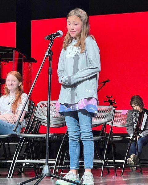 Student standing at microphone for spelling bee